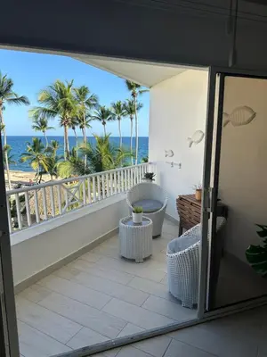 a balcony with a view of the ocean and palm trees at Apartamento lll Vista al Mar Albatros by ju Juan Dolio in Villas del Mar