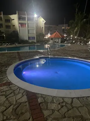 a large blue pool with a faucet in a yard at Apartamento lll Vista al Mar Albatros by ju Juan Dolio in Villas del Mar