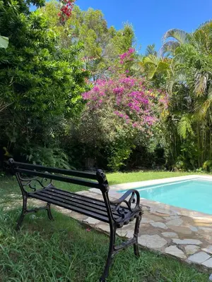 a black bench sitting next to a swimming pool at Beautiful, fresh peaceful Villa in Sosúa
