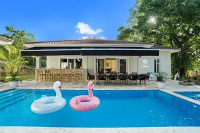 two inflatable swans in a swimming pool in front of a house at Modern 6 Br Villa With Hot Tub in Sosúa