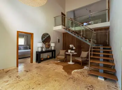 a living room with a staircase and a bedroom at Modern 6 Br Villa With Hot Tub in Sosúa