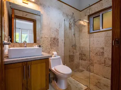 a bathroom with a toilet and a sink and a shower at Modern 6 Br Villa With Hot Tub in Sosúa