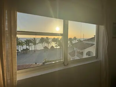 a window with a view of the beach and the ocean at Cadaques Bayahibe Beach Front in Bayahibe