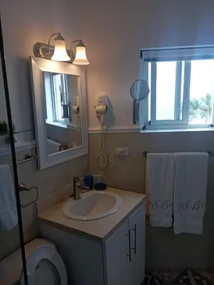 a bathroom with a sink and a mirror and a toilet at Cadaques Bayahibe Beach Front in Bayahibe