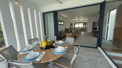 a dining room and living room with a table and chairs at Oceanview Villa With King Beds in Las Terrenas
