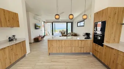 a large kitchen with wooden cabinets and a large sink at Oceanview Villa With King Beds in Las Terrenas