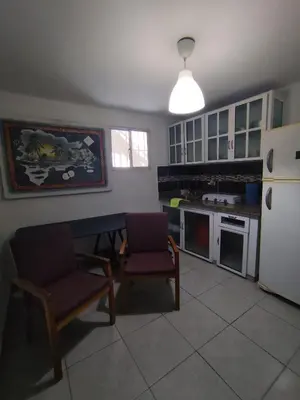 a kitchen with a table and two chairs and a refrigerator at Cruce Caribeña in Boca Chica