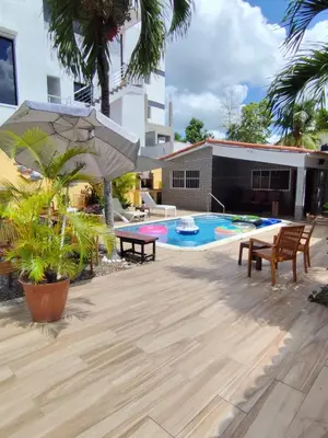 a patio with a table and chairs and a pool at Cruce Caribeña in Boca Chica
