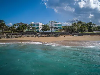 a view of a beach with buildings in the background at Tropical Gem by the Sea in Sosúa