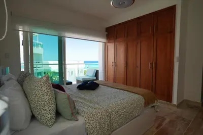 a bedroom with a bed and a large window at Tropical Gem by the Sea in Sosúa