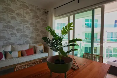a potted plant sitting on a wooden table in a living room at Tropical Gem by the Sea in Sosúa