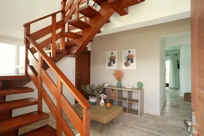 a staircase in a living room with a table at Tropical Gem by the Sea in Sosúa