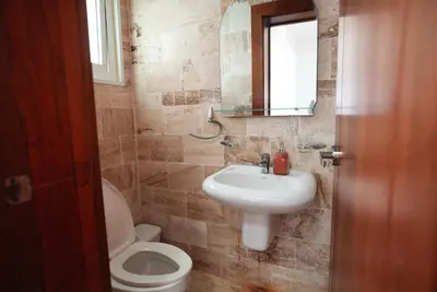 a bathroom with a sink and a toilet and a mirror at Tropical Gem by the Sea in Sosúa