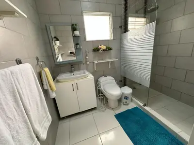 a bathroom with a toilet and a sink and a mirror at Casa en la Autopista de San Isidro in Hainamosa
