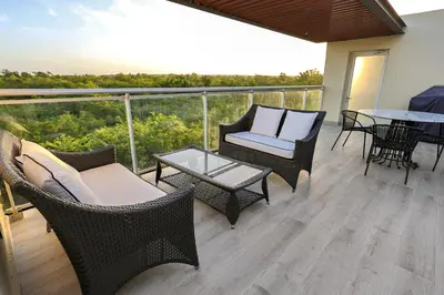 a balcony with wicker chairs and tables and a view at 504 New, Fantastic Rooftop with Private Jacuzzi in La Laguna