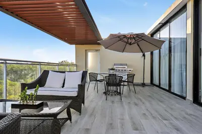 a patio with a couch and a table with an umbrella at 504 New, Fantastic Rooftop with Private Jacuzzi in La Laguna