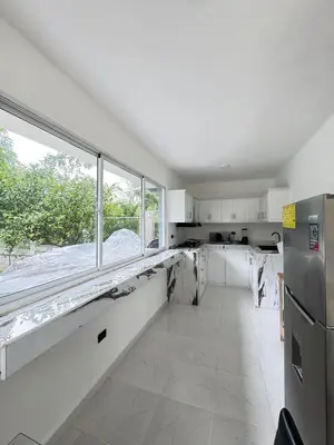 a kitchen with white cabinets and a large window at villa el naciente in La Cuaba
