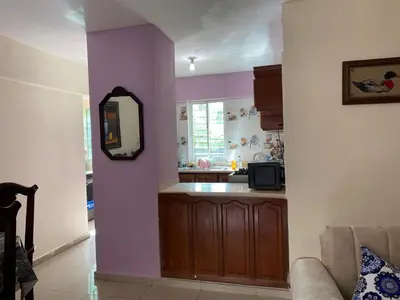 a living room with a kitchen with purple walls at Brisa de mar BOCA CHICA, in Boca Chica