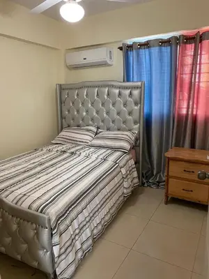 a bedroom with a bed with a headboard and a table at Brisa de mar BOCA CHICA, in Boca Chica