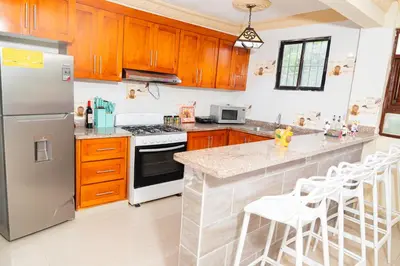 a kitchen with wooden cabinets and a stainless steel refrigerator at Rancho Juliana in Villas del Mar