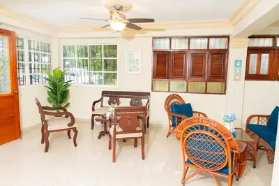 a living room with chairs and tables and a ceiling fan at Rancho Juliana in Villas del Mar