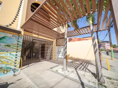 a wooden pergola on a building with a palm tree at 2BR Colonial Penthouse in Sosua next to BEACH in Sosúa