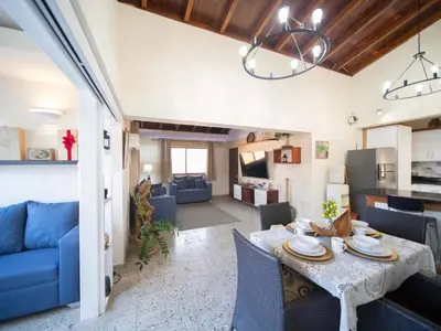 a kitchen and living room with a table and a blue couch at Colonial 2BR Apartment 2mins walk to beach in Sosúa