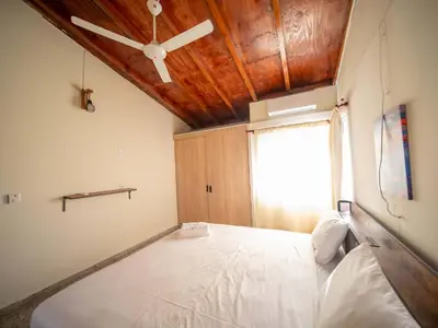 a bedroom with a large bed with a wooden ceiling at Colonial 2BR Apartment 2mins walk to beach in Sosúa