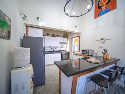 a kitchen with a refrigerator and a counter top at Colonial 2BR Apartment 2mins walk to beach in Sosúa