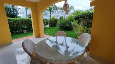 a table and chairs on a patio with a view of a yard at Caribe Home Dominicus Ginepro 3 in La Laguna