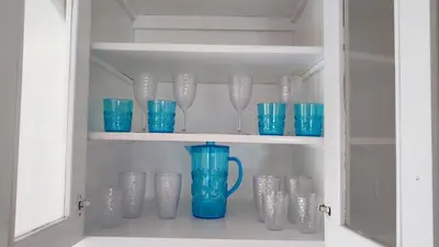 a cabinet filled with blue glass vases and cups at Caribe Home Dominicus Ginepro 3 in La Laguna
