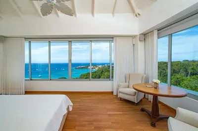 a bedroom with a bed and a table and a window at 5 mins from beach, Hilltop villa with pool in La Pared