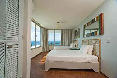 a bedroom with two beds and a large window at 5 mins from beach, Hilltop villa with pool in La Pared
