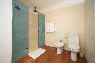 a bathroom with a toilet and a glass shower at 5 mins from beach, Hilltop villa with pool in La Pared