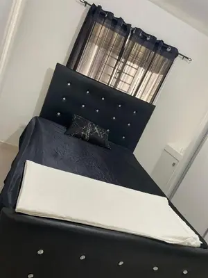 a black bed with a black headboard and a window at Apartamento en ciudad Juan bosch con todas las amenidades in Los Paredones
