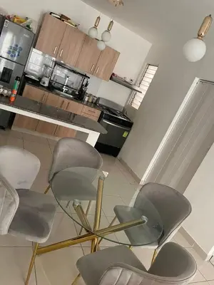 a kitchen with four chairs in front of a counter at Apartamento en ciudad Juan bosch con todas las amenidades in Los Paredones