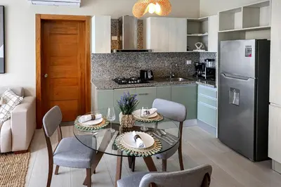 a kitchen with a table with chairs and a refrigerator at 404-C Luxurious Apartment 5 Minutes from the Beach in La Laguna