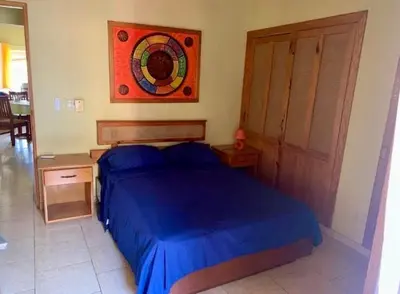 a bedroom with a blue bed and a painting on the wall at Condo Sosúa in Sosúa