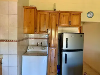 a kitchen with a white refrigerator and wooden cabinets at Condo Sosúa in Sosúa