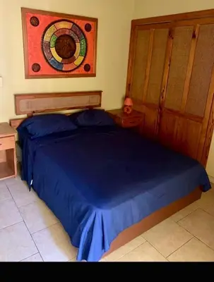 a bedroom with a blue bed with a wooden headboard at Condo Sosúa in Sosúa