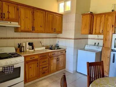 a kitchen with wooden cabinets and a white appliance at Condo Sosúa in Sosúa