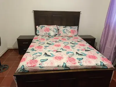 a bed with a bedspread with roses on it at Kasita del sol boca chica in Boca Chica