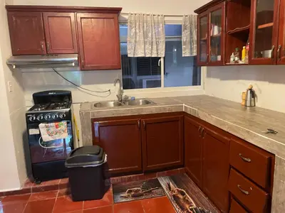 a kitchen with wooden cabinets and a sink and a stove at Kasita del sol boca chica in Boca Chica