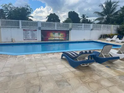 a swimming pool with two lounge chairs next to it at Kasita del sol boca chica in Boca Chica