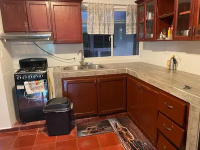 a kitchen with wooden cabinets and a sink and a trash can at Kasita del sol boca chica in Boca Chica