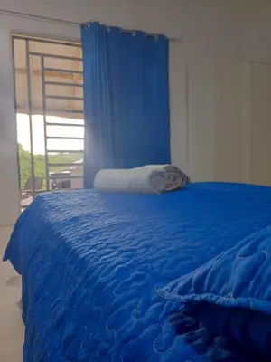 a blue bed with a blue sheets and a window at Encuentra tu Alma in Las Terrenas