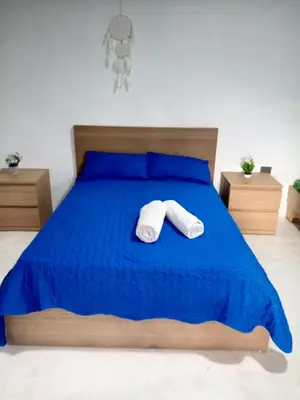 a bedroom with a blue bed with towels on it at Encuentra tu Alma in Las Terrenas
