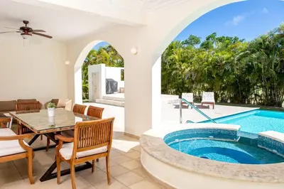 a home with a swimming pool and a dining room with a table and chairs at Stunning 4 BR Luxury Villa in Punta Cana
