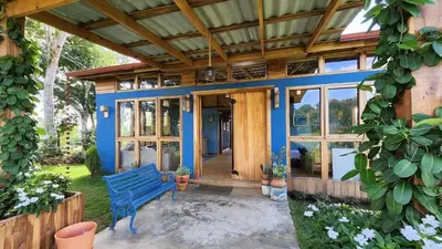 a blue bench sitting in front of a house at MaRaVillas DR in the mountains excellent location in Jarabacoa