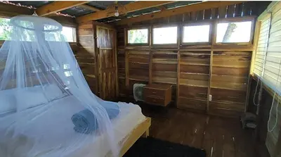 a bedroom with a bed in a wooden cabin at MaRaVillas DR in the mountains excellent location in Jarabacoa